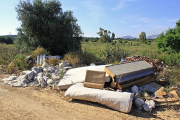 Illegal garbage dump across forest road