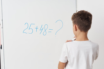boy drawing with chalk on blackboard