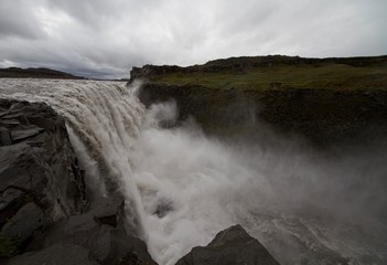 On the edge of the powerful Dettifoss waterfall in Iceland