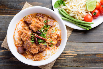 Northern Thai food (Kanom Jeen Nam Ngeaw), rice noodles with spicy soup eating with vegetables, top view	