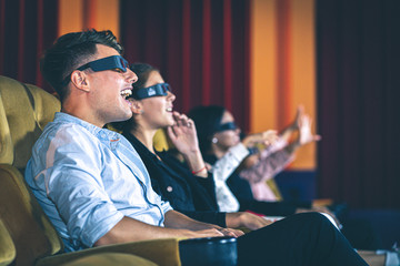 People having fun watching 3d movie in the cinema.