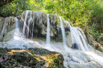Obraz premium Waterfall and blue emerald water color in Erawan national park. Erawan Waterfall, Beautiful nature rock waterfall steps in tropical rainforest at Kanchanaburi province, Thailand
