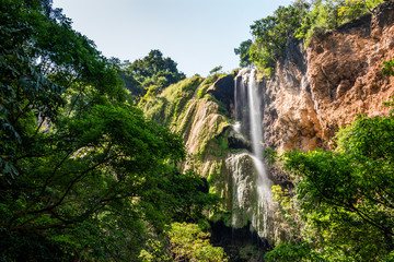 Waterfall flowing from high mountain cliff in Erawan national park. Erawan Waterfall 7 tier, Beautiful nature rock waterfall in tropical rainforest at Kanchanaburi province, Thailand