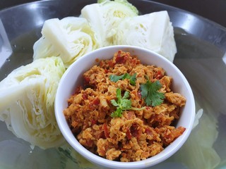 Thai food style, Top view of spicy Northern Thai pork with tomato and boiled cabbage in bowl as a background, This food is most popular Thai food, Nam Prik Aong is Thai traditional