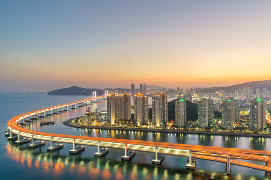 Busan city skyline in Haeundae business district area skyline view from roof top at night in Busan ,South Korea. Asian tourism, modern city life, or business finance and economy concept. - Powered by Adobe