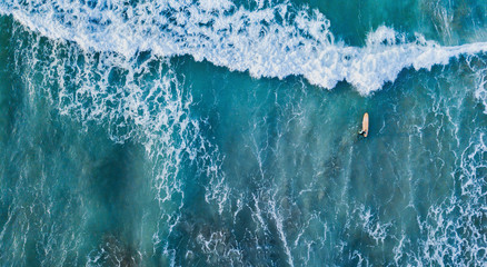 surfer in the ocean top down aerial view in blue waves, banner background