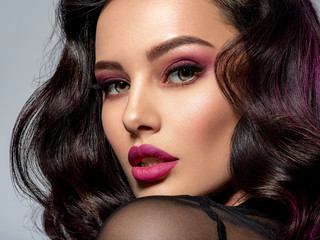Portrait of beautiful young woman with bright maroon makeup. Beautiful brunette with bright cherry...