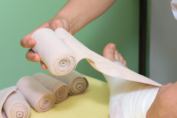 Lymphedema management: Wrapping leg using multilayer bandages to control Lymphedema. Part of complete decongestive therapy (cdt) and manual lymphatic drainage (MLD)