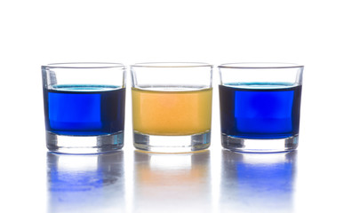 several shot glasses with different drinks, which combined represent the flag of a country
