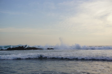 the beach in the afternoon with calm waves and sunny weather against a backdrop of open sea and coral	