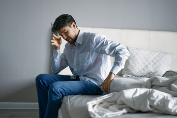 man sitting on sofa and talking on cell phone