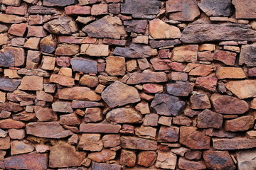 OLD HANDMADE WALL WITH NATURAL STONES STACKED ONE OVER OTHERS