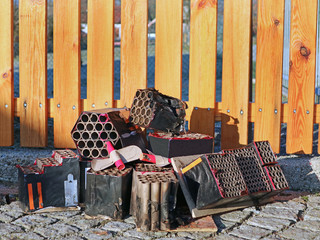 Burned out firework batteries after silvester in front of garden fence with copy space