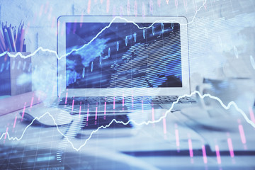 Stock market chart hologram drawn on personal computer background. Double exposure. Concept of investment.