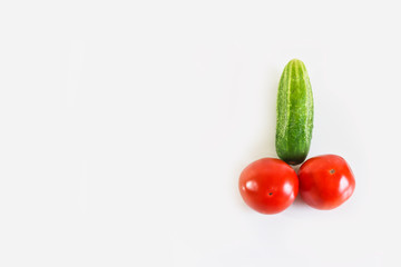 Red ripe juicy tomatoes and green cucumber. The phallic image of natural components. Light gray background