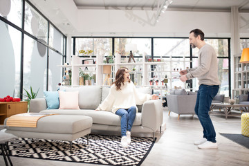 Obraz premium Couple discussing furniture models in a modern furniture shop