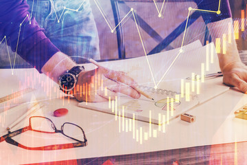 Financial trading chart double exposure with man desktop background.