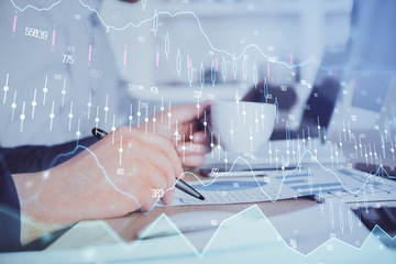 Double exposure hands with stock market chart.