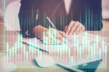 Forex graph on hand taking notes background. Concept of research. Multi exposure