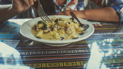 Yummy pasta on cafe table. Closeup plate with portion of tasty pasta with cream sauce placed on...