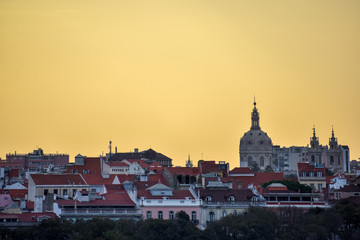 Obraz premium Lisbon skyline view. Colorful walls of the buildings of Lisbon, with orange roofs and the Basílica da Estrela at sunset. Travel and real estate concept. Lisbon, Portugal. Europe.