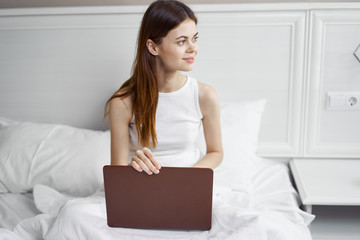 woman using her laptop in bed