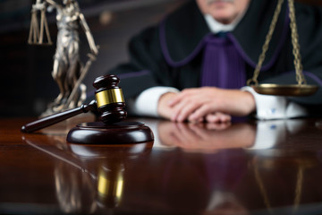 Law theme – judge in toga with the gavel during trial.