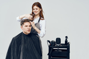 woman hairdresser doing hairstyle to man