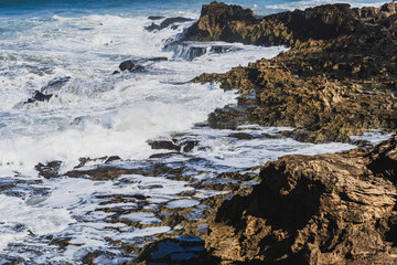 Fototapeta na wymiar Rocas en la costa golpeadas por las olas del mar