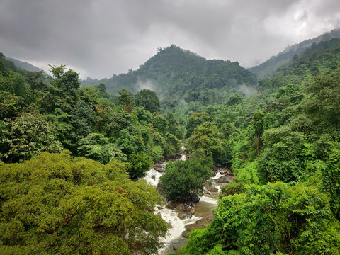 Landscape image of Thusharagiri Falls between dense green forest in Wayanad, Kerala, India.