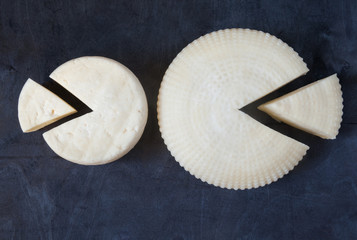 Homemade farm cheese on black background.