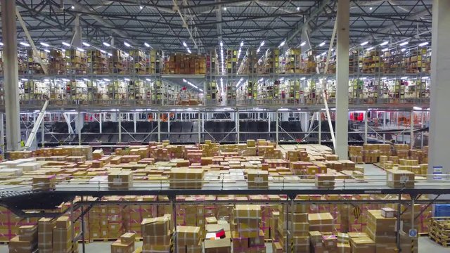 Large modern warehouse with cardboard boxes inside on logistic center, AERIAL