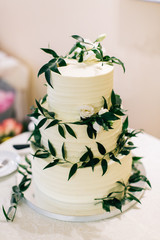 White wedding cake beautifully decorated with flowers and greenery