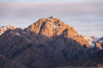 Sunrise over residual snowy mountain in the dawn