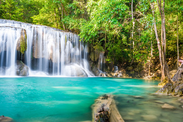 Fototapeta na wymiar Waterfall and blue emerald water color in Erawan national park. Erawan Waterfall , Beautiful nature rock waterfall steps in tropical rainforest at Kanchanaburi province, Thailand