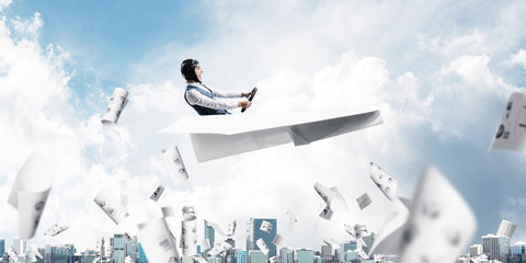 Businessman in aviator hat driving plane