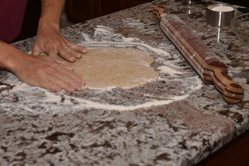 Preparing dough for making cookies with the help of a child's hands.