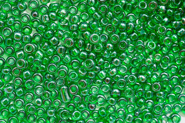 Bright green beads for making jewelry shot large on a white background