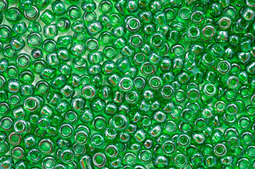 Bright green beads for making jewelry shot large on a white background