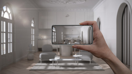 Hand holding smart phone, AR application, simulate furniture and interior design products in real home, architect designer concept, blur background, classic living room with kitchen