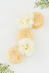 Fototapeta na wymiar French sweet vanilla macarons cookies on white wooden table . Dessert