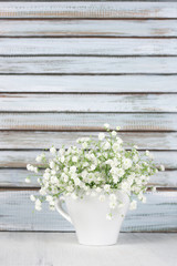 Fototapeta na wymiar White flowers bouquet against wooden shutters