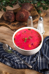 Red borscht soup in bowl.