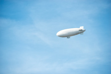 Fototapeta na wymiar zeppelin on the blue sky in summer time