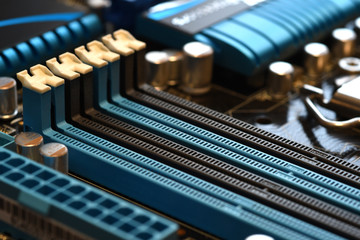 Electronics components on modern PC computer motherboard with RAM connector slot.