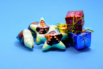 Chocolate stars and gifts on a blue background. Congratulation. Valentine's Day. Soft focus