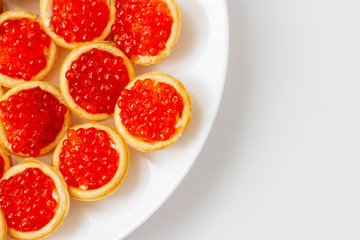 Fototapeta na wymiar red caviar in tartlets on a white saucer