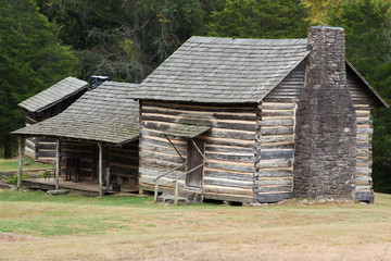Obraz premium Log Cabin in a field of grass