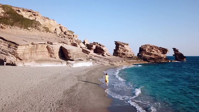 Aerial Drone Footage of a girl running along a lonely beach