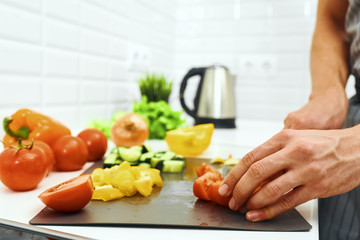 Obraz na płótnie Canvas woman cutting vegetables in kitchen